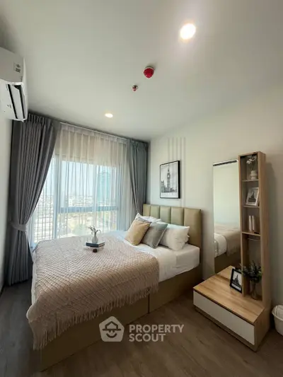 Modern bedroom with large window and stylish decor in a high-rise apartment.