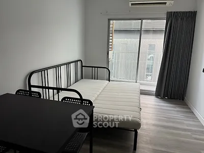 Modern minimalist bedroom with sleek metal bed frame and large window for natural light.