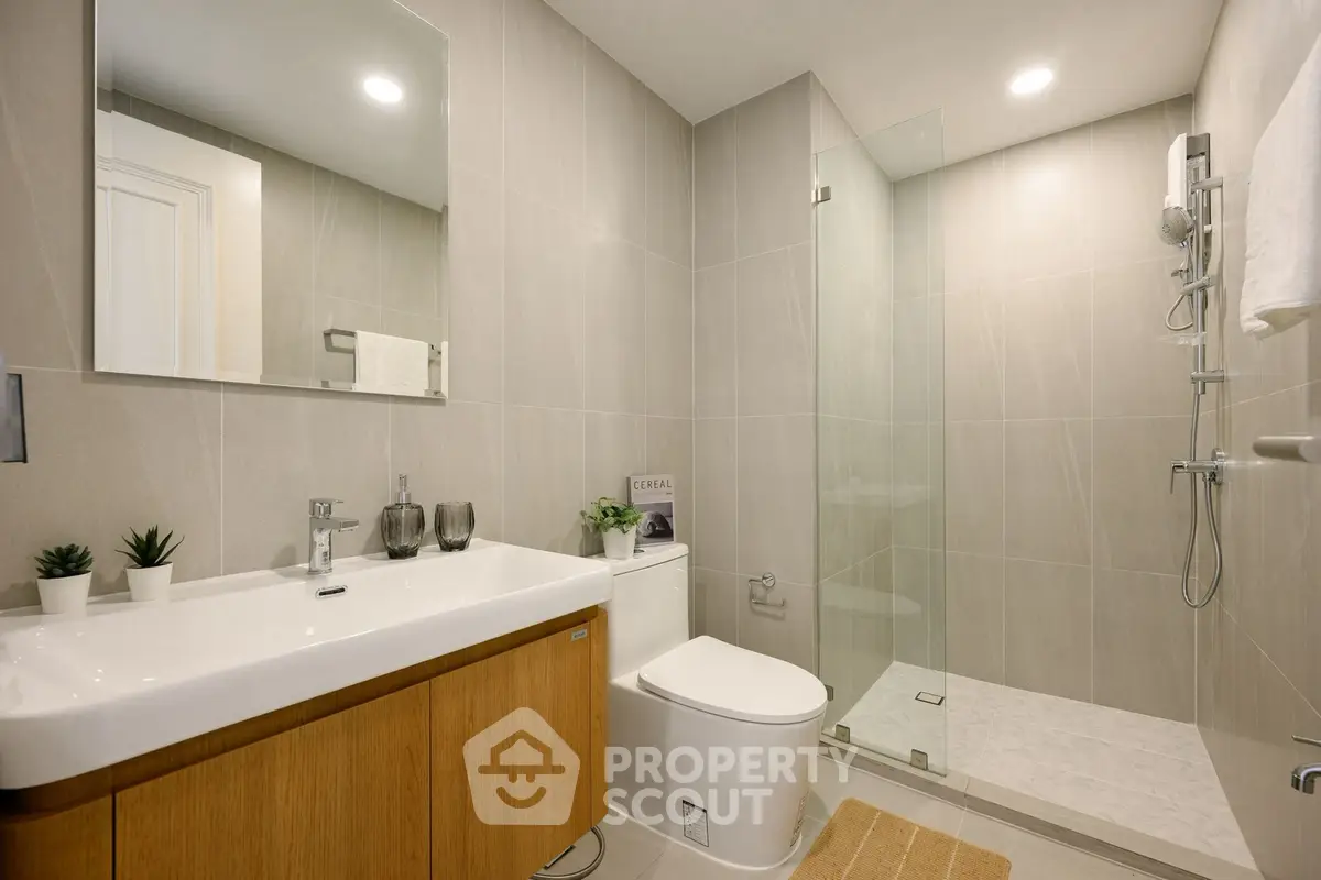 Modern bathroom with sleek fixtures and glass shower in contemporary home.