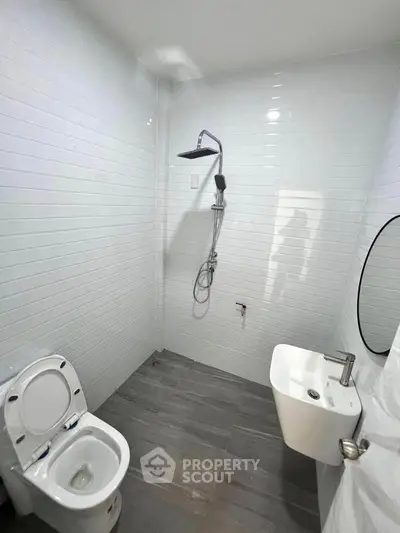 Modern minimalist bathroom with sleek fixtures and white tiled walls.