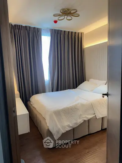 Cozy bedroom with elegant curtains and modern lighting, perfect for relaxation.
