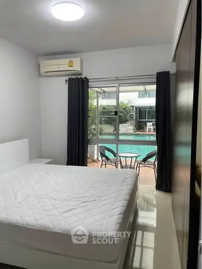 Modern bedroom with pool view and cozy balcony seating