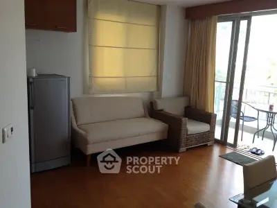 Bright living room with balcony access and cozy seating area.
