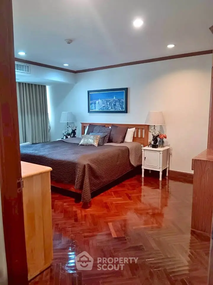 Spacious bedroom with elegant decor and polished wooden flooring