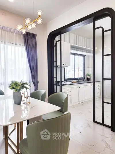 Elegant kitchen with open layout and chic dining area, featuring modern decor and ample natural light.