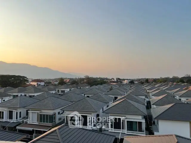 Stunning aerial view of modern suburban houses at sunset, showcasing uniform architecture and serene surroundings.