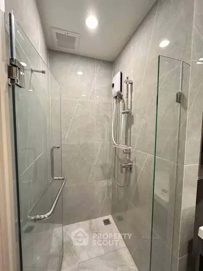 Modern bathroom with sleek glass shower enclosure and elegant tile design.