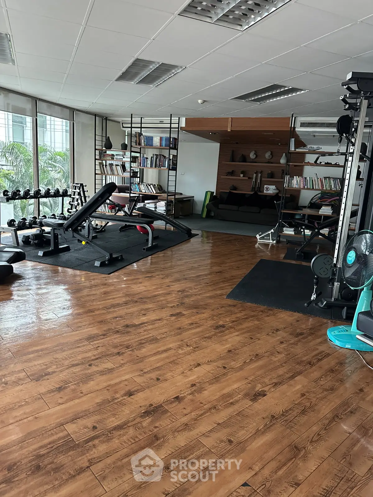 Spacious home gym with modern equipment and wooden flooring, perfect for fitness enthusiasts.