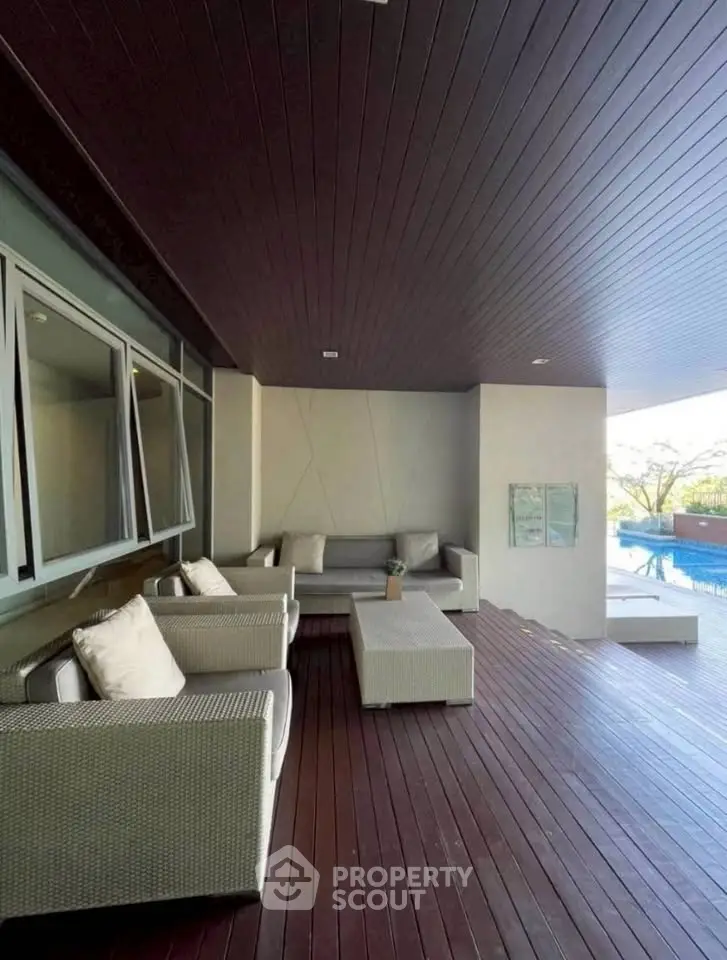 Luxurious poolside lounge with modern wicker furniture and wooden deck