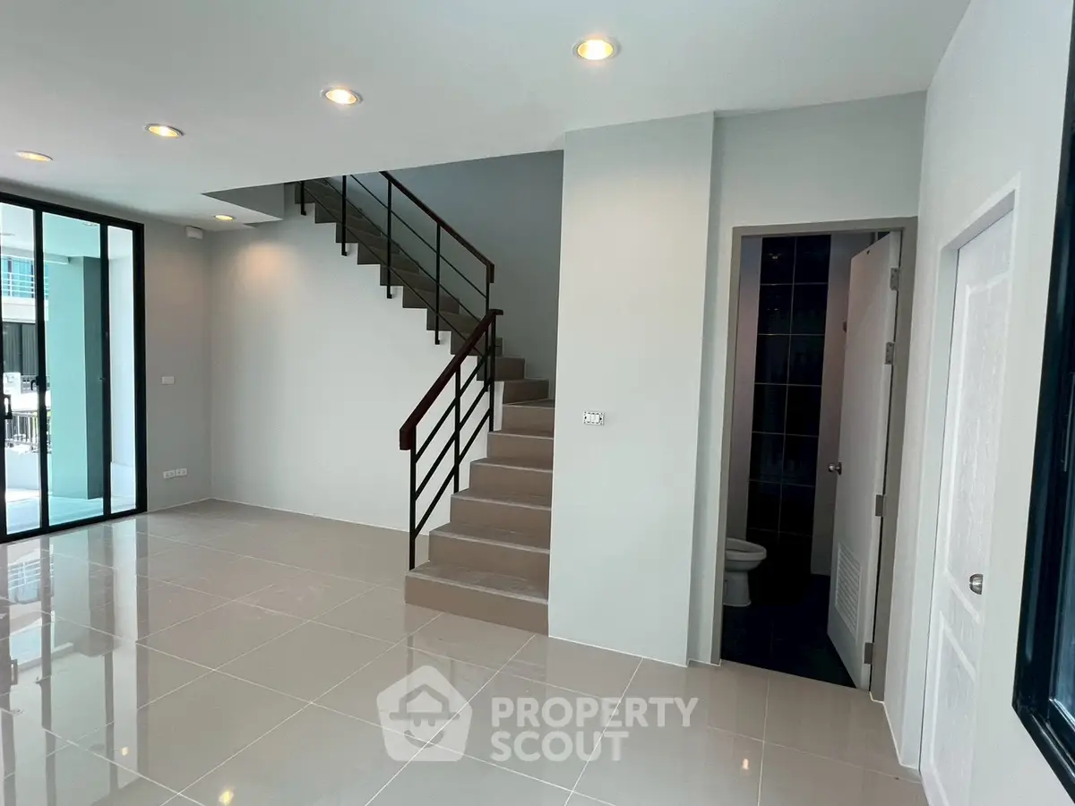 Modern interior with sleek staircase and tiled flooring, perfect for contemporary living.