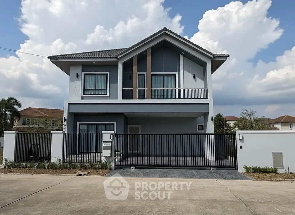 Modern two-story house with sleek design and gated entrance in a suburban neighborhood.