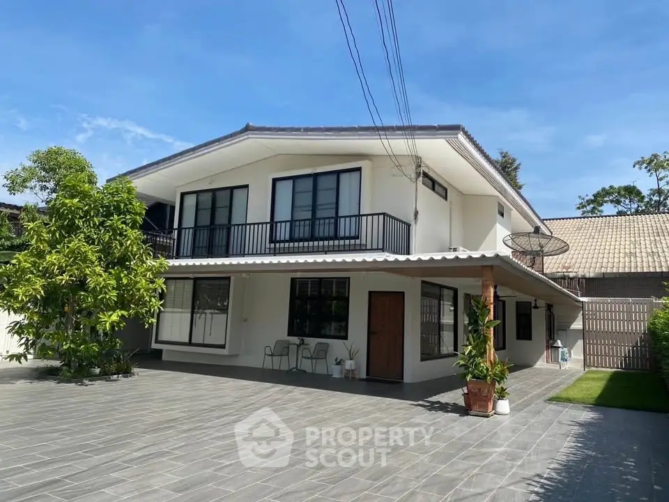 Spacious modern two-story house with large driveway and lush greenery, perfect for family living.