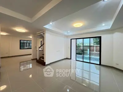Spacious modern living room with glossy tiled floors and large windows.
