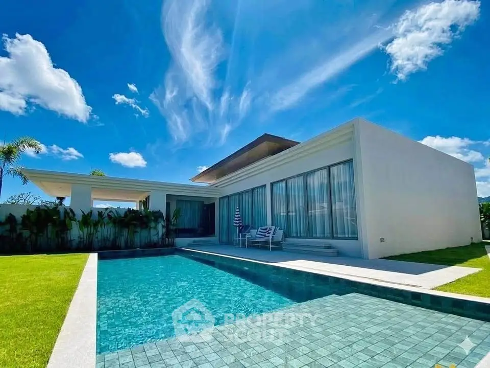 Luxurious modern villa with private pool and lush garden under a clear blue sky.