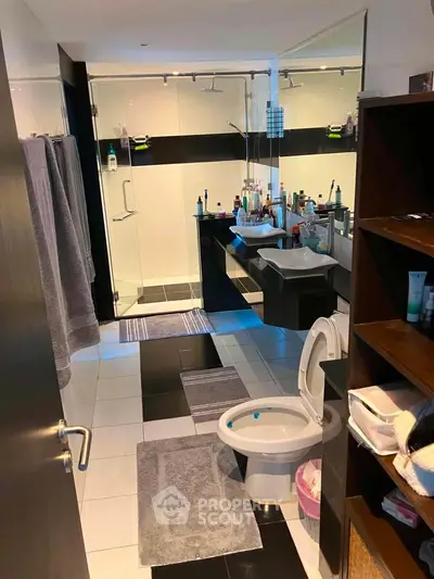 Modern bathroom with sleek design, glass shower, and ample storage space.