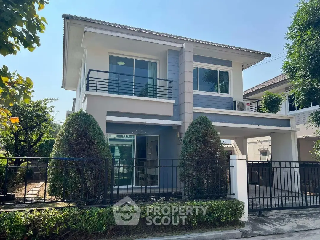 Modern two-story house with manicured garden and sleek design in a suburban neighborhood.