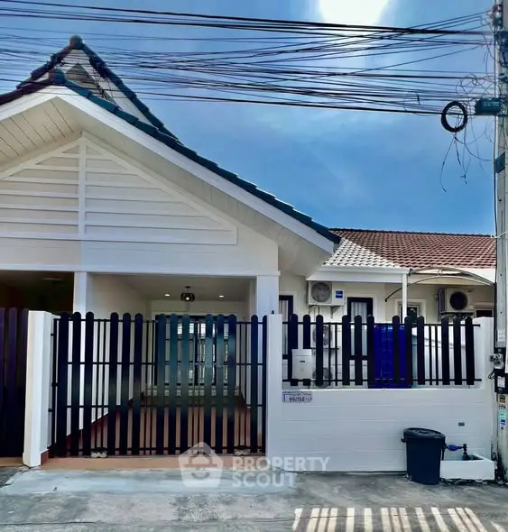 Charming single-story home with modern facade and gated entrance, perfect for family living.