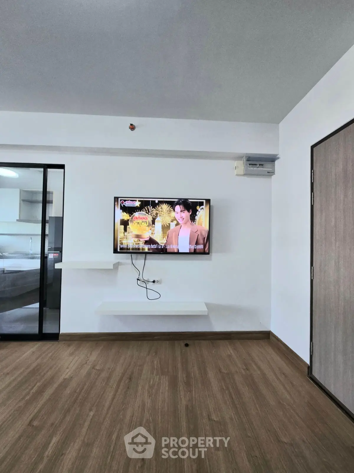 Modern living room with mounted TV and sleek wooden flooring