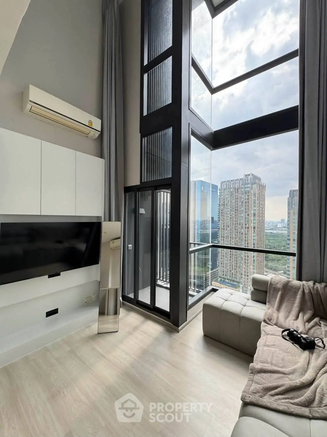 Luxurious high-rise living room with floor-to-ceiling windows and stunning city view.