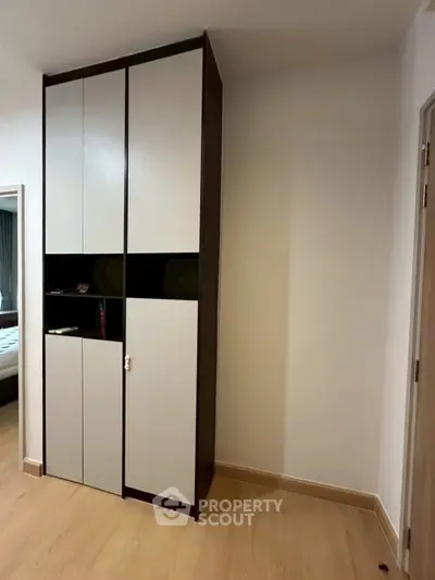 Modern bedroom with sleek wardrobe and wooden flooring