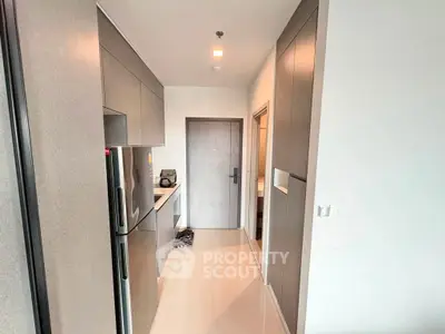 Modern kitchen with sleek cabinetry and stainless steel appliances in a contemporary apartment.