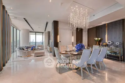 Luxurious open-plan living and dining area with elegant chandelier and panoramic city views.