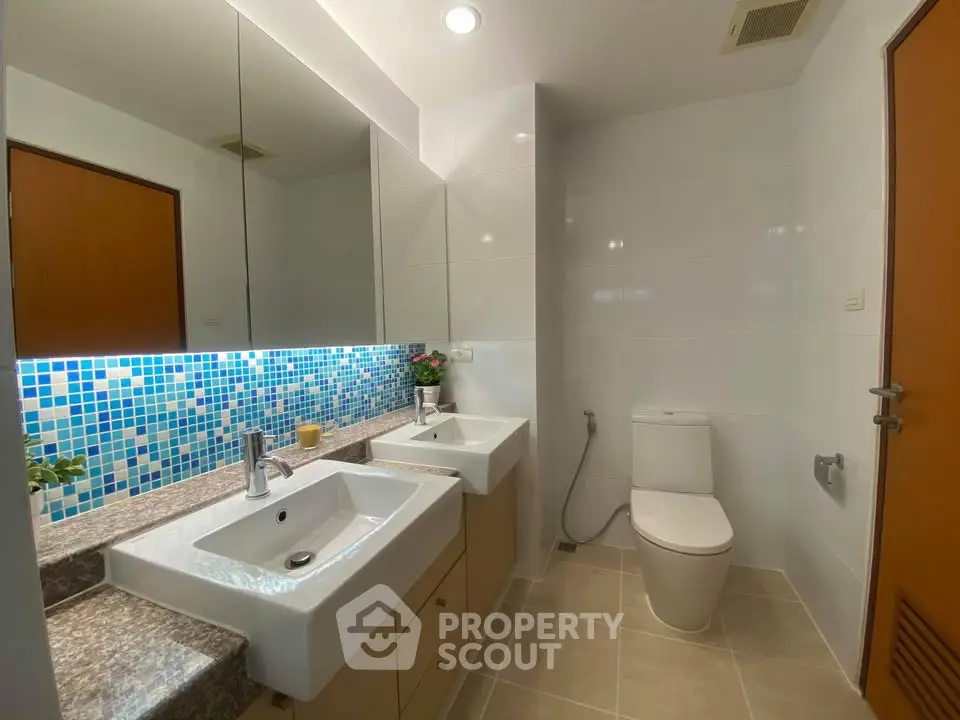 Modern bathroom with dual sinks and stylish mosaic backsplash