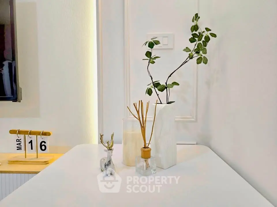 Modern minimalist interior with decorative plants and calendar on a sleek white table.