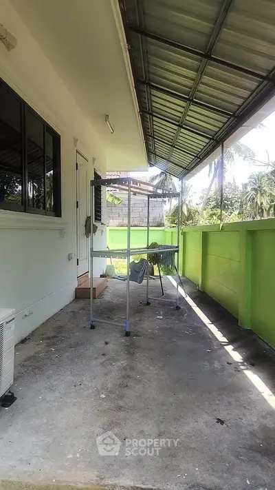 Spacious balcony with green wall and tropical view, perfect for relaxation and outdoor activities.