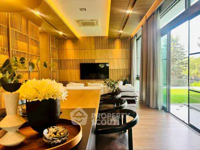 Luxurious modern living room with wooden accents and large windows overlooking greenery.