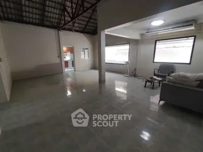Spacious living room with tiled floor and large windows in a modern home.