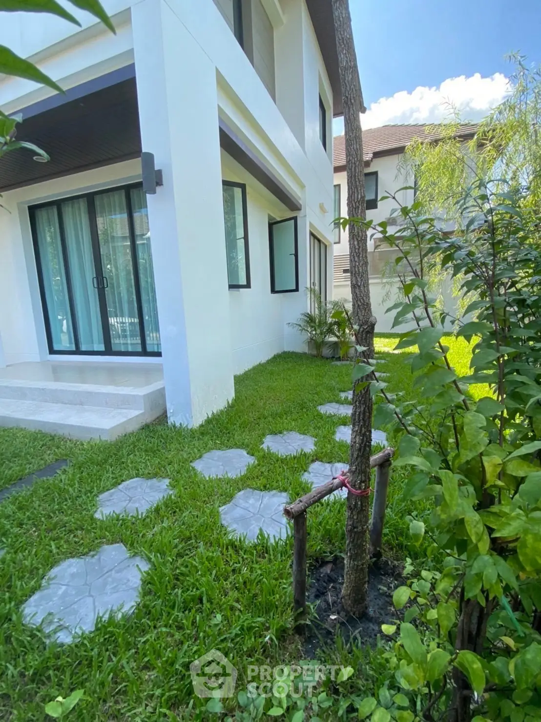 Modern home exterior with lush garden and stepping stones