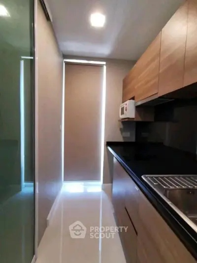 Modern kitchen with sleek cabinets and glossy countertops in a compact layout.