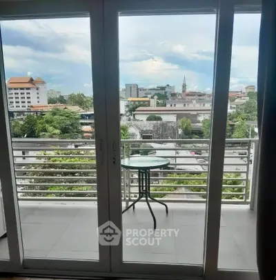 Spacious balcony with stunning city view through glass doors