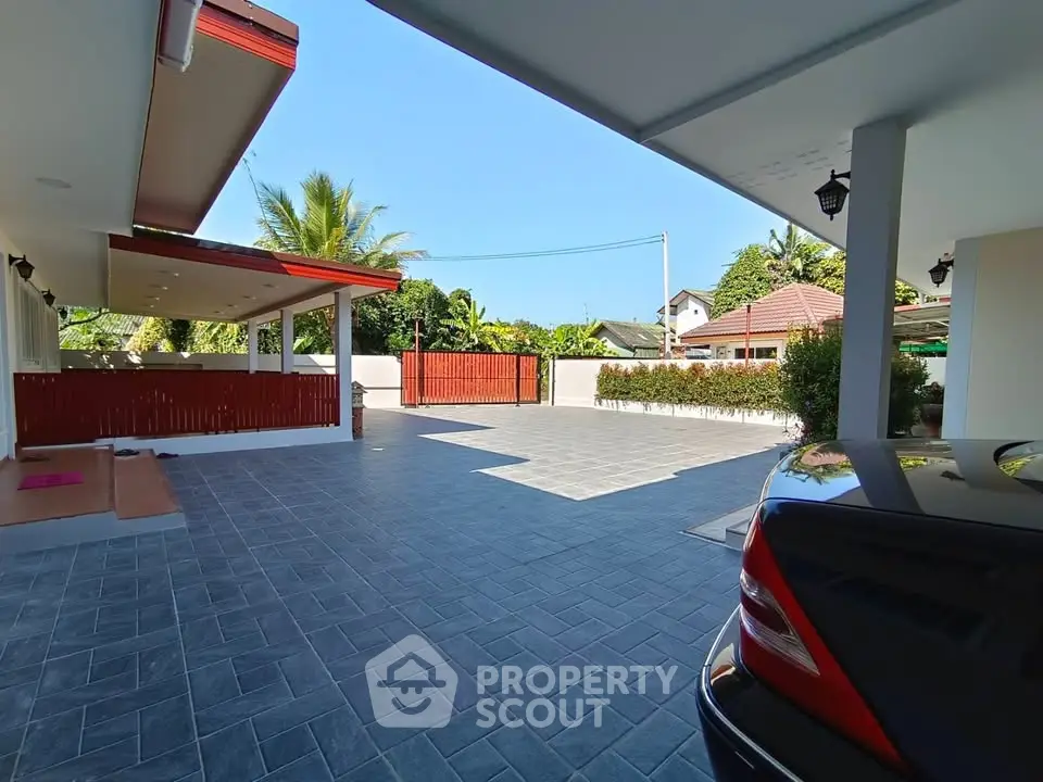 Spacious modern driveway with sleek car and lush greenery, perfect for a luxurious lifestyle.