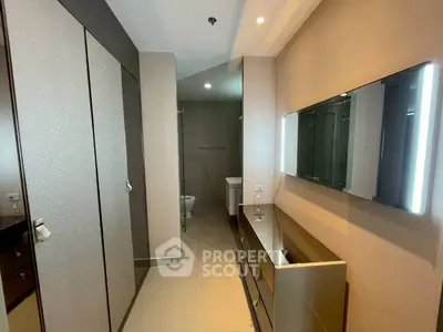 Modern bathroom with sleek cabinetry and large mirror in a contemporary apartment.