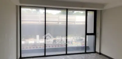 Spacious room with large windows offering urban street view, perfect for natural light lovers.