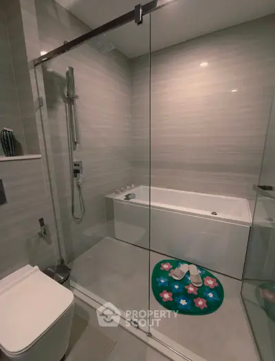 Modern bathroom with glass shower and bathtub in sleek design