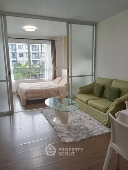 Charming studio apartment with cozy living area and bright bedroom, featuring large windows and modern decor.