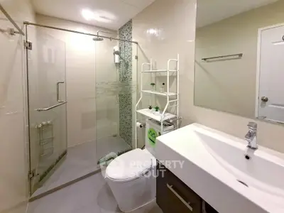 Modern bathroom with glass shower enclosure and sleek white fixtures