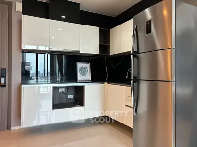 Modern kitchen with sleek cabinets and stainless steel fridge in a stylish apartment.