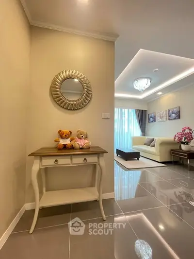 Elegant living room with plush sofa and stylish decor, featuring a cozy corner with teddy bears on a chic console table.