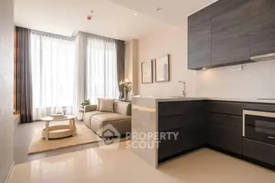 Modern open-layout living room and kitchen with sleek design and natural light.