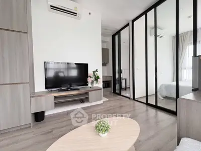 Modern living room with sleek design and mirrored sliding doors leading to a cozy bedroom.