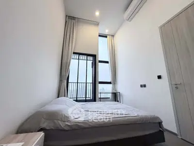 Modern bedroom with high ceiling and large window offering city view