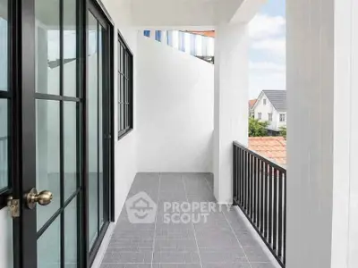 Spacious balcony with modern railing and tiled floor offering a serene view of suburban rooftops.