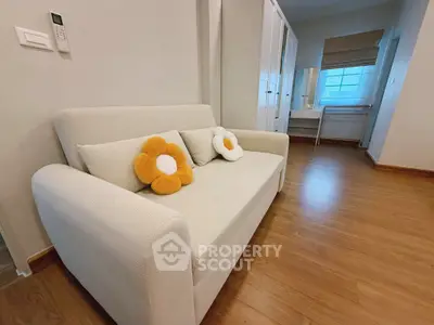 Cozy living room with stylish sofa and wooden flooring, perfect for relaxation.