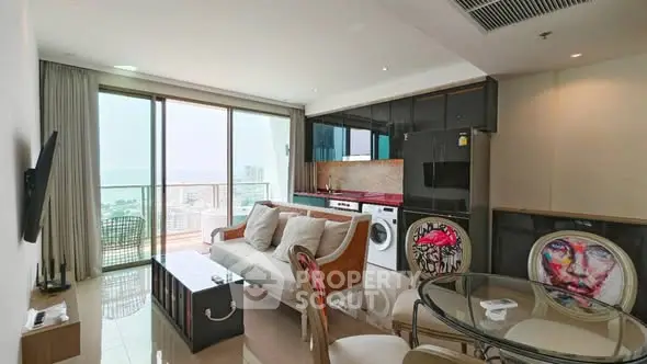 Modern living room with balcony view, stylish furniture, and integrated kitchen appliances in a high-rise apartment.