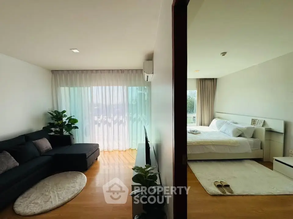 Modern apartment with spacious living room and cozy bedroom, featuring elegant decor and natural light.