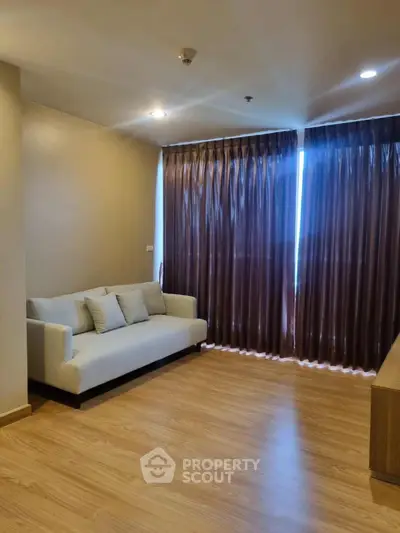 Spacious living room with cozy sofa and elegant curtains